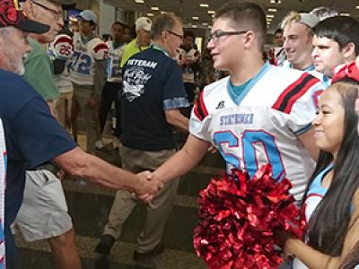 football player shakes a veteran's hand